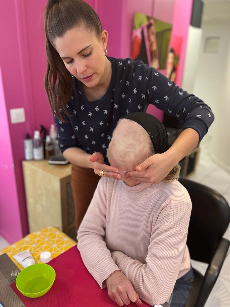 Lise doing a facial massage to a woman
